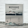 QUAD Dispenser in stainless steel 'Mondays Organic' branding on a wooden surface holds 2 types of applicator tampons and two types of sanitary pad.
