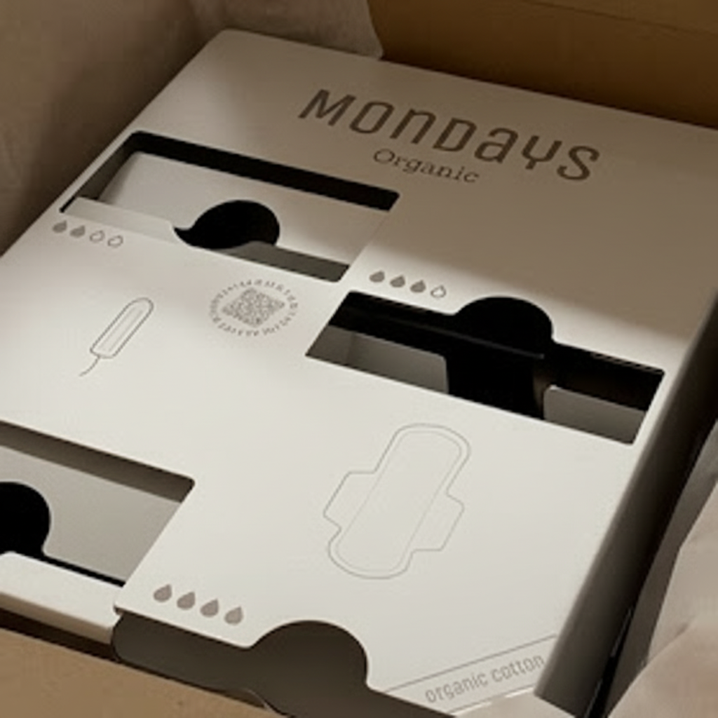 Stainless Steel Mondays QUAD-D Menstrual Product Dispenser for 2 types of non-applicator tampon and 2 types of sanitary pad sitting in it's 100% plastic-free packaging